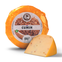 Un petit fromage de vache au cumin dans son emballage avec un morceau de fromage devant