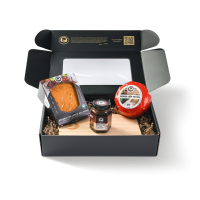 Schwarze Geschenkbox mit zwei Käsesorten, einem Käsebrett und einem Käsedip.