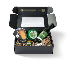 Twee kazen, een fles witte wijn en een kaasmesje in de verpakking. Gedisplayd in een zwarte doos.