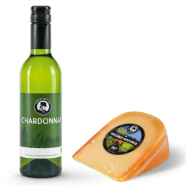 A bottle of white wine with a piece of cheese alongside it.