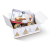 Schachtel mit Geschenkset, darunter Käse und ein Käseschneider in Verpackung.