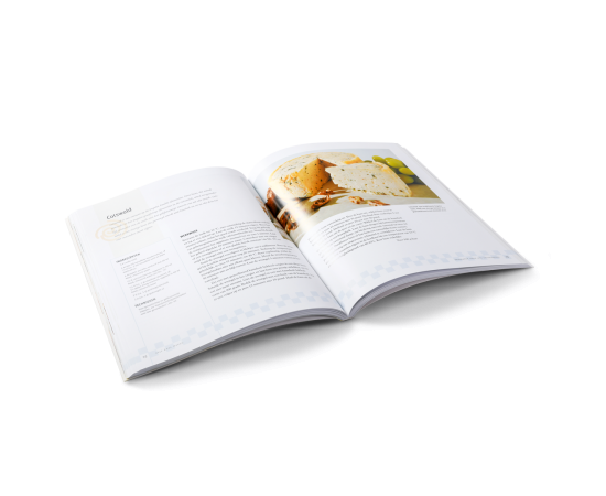 Offenes Kochbuch mit Rezept für selbstgemachten Käse