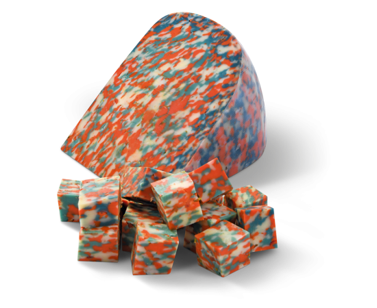 "Red, white and blue colored cheese from Henri Willig with loose cheese cubes in front of it."