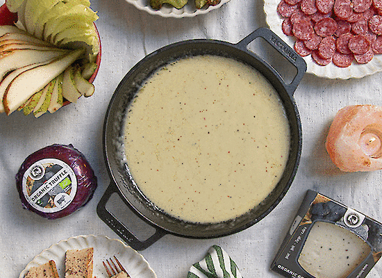 Käsefondue-Topf mit Häppchen auf dem Tisch