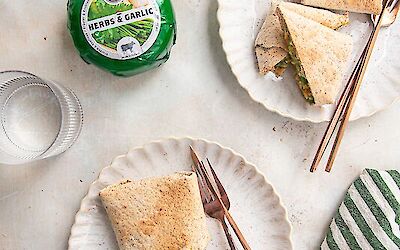 Wrap met kip, pesto, kaas en knoflook op twee borden geserveerd