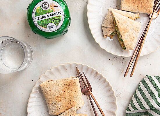 Wrap with chicken, pesto, cheese, and garlic served on two plates.