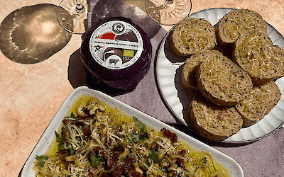 Loaded Mediterrane Dip met Henri Willig Kalamata Olijf Tomaat Kaas, olijfolie, zongedroogde tomaten, olijven en kruiden, geserveerd met knapperig stokbrood.