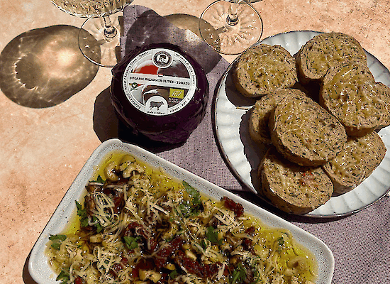 Loaded Mediterrane Dip met Henri Willig Kalamata Olijf Tomaat Kaas, olijfolie, zongedroogde tomaten, olijven en kruiden, geserveerd met knapperig stokbrood.